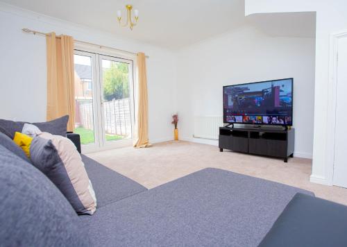 a living room with a couch and a flat screen tv at Intellect Suites in Northampton