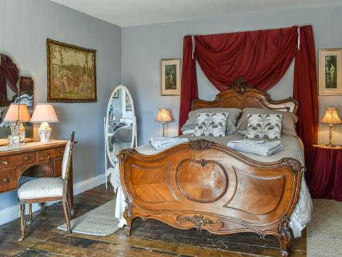 um quarto com uma cama de madeira, uma cómoda e um espelho em Wellesley Retreat em Hastings