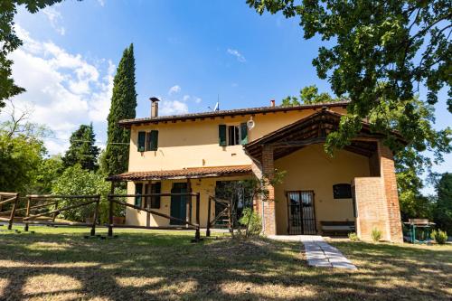 an exterior view of a house with a tree at Agriturismo Montevecchio Isolani in Monte San Pietro