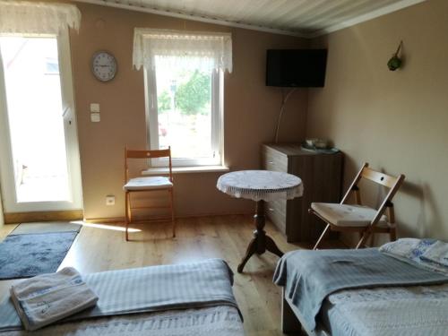 1 dormitorio con 2 camas, mesa y ventana en Pokój 2-osobowy z balkonem, en Gdansk