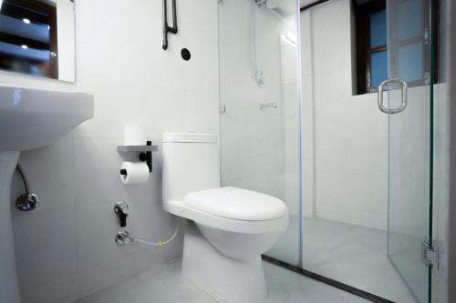 a bathroom with a toilet and a glass shower at Karuna Hotel Patan Kathmandu in Pātan
