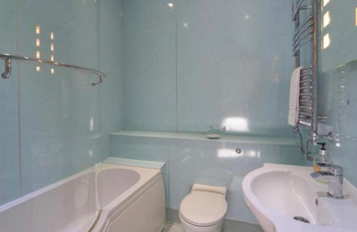 a bathroom with a tub and a toilet and a sink at Southbank Guesthouse in Elgin