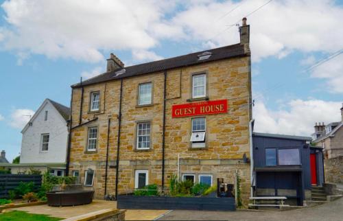 un edificio de ladrillo con un cartel que lee el hostal en Southbank Guesthouse, en Elgin