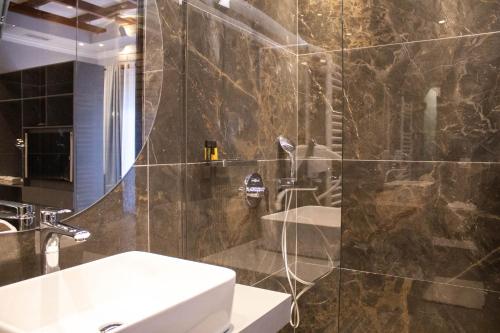 y baño con lavabo y ducha. en Venis Hotel, en Tirana