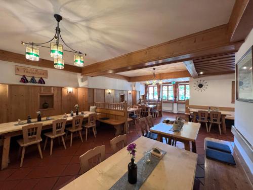 ein leeres Esszimmer mit Tischen und Stühlen in der Unterkunft Gasthaus Kampenwand Bernau in Bernau am Chiemsee