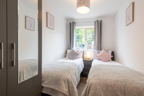 two beds in a room with a mirror at No 14 in Mansfield