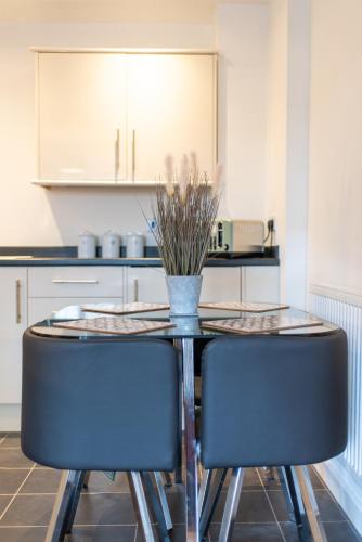a dining room table with two chairs and a vase on it at No 14 in Mansfield