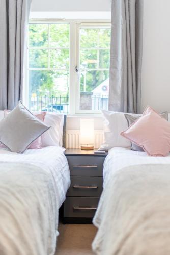 two beds in a room with a window at No 14 in Mansfield
