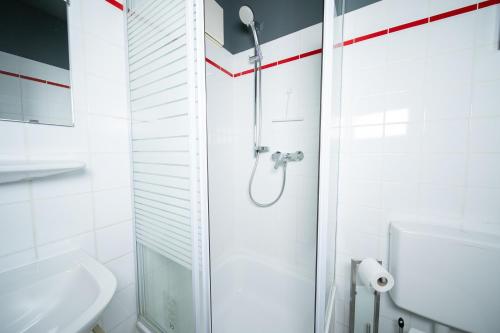 a white bathroom with a shower and a sink at Studio WHITE - Central - Balcony - Fair - Kitchen in Neuss