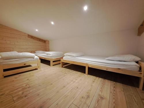 two bunk beds in a room with wooden floors at Aillon Evasion 12 in La Correrie