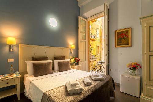 a bedroom with a large bed with two towels on it at Marlin Rooms in Cagliari