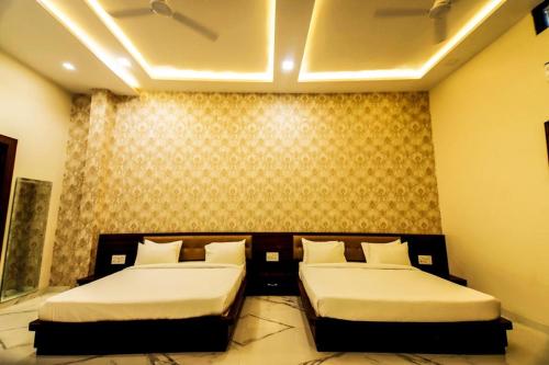 2 Betten in einem Hotelzimmer mit 2 Betten sidx sidx sidx sidx in der Unterkunft Hotel Amar Vilas & Resort in Bharatpur