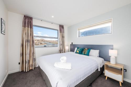 a bedroom with a large bed with a window at 37 Galaxy A in Lake Tekapo