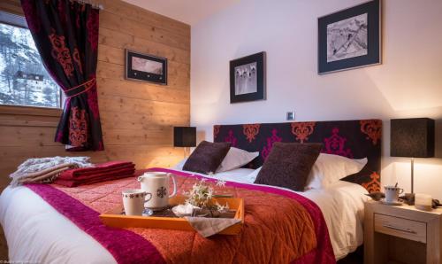 um quarto com 2 camas com lençóis vermelhos e brancos em CGH Résidence Boutique Le Lodge des Neiges em Tignes