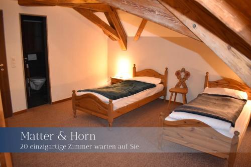 una camera con due letti in mansarda di Hotel Herberge a Teufenthal
