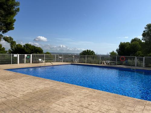 a large blue swimming pool with a fence around it at Apartamento Aventura in Salou