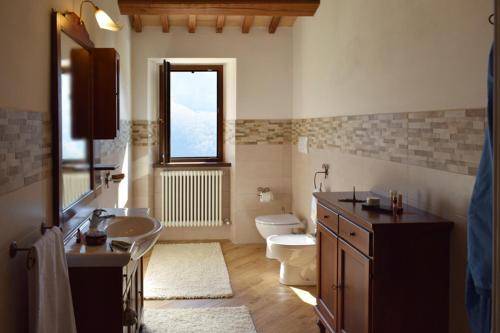 baño con aseo y ventana en Cà Rossara - Ala Ubaldini - Ala Brancaleoni, en Pian di Mulino