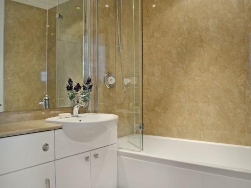 a bathroom with a sink and a shower at Summerlea Cottage in Moffat