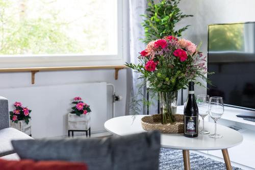 - une table avec un vase de fleurs et une bouteille de vin dans l'établissement Family Home Vanamo, à Rovaniemi