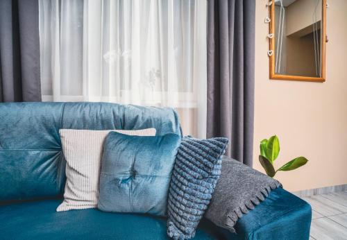 Un sofá azul con almohadas en una sala de estar. en Cozy Stay Apartment, en Kaunas