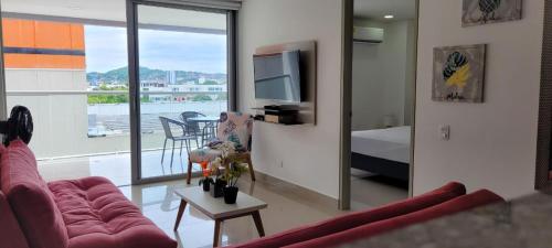 uma sala de estar com um sofá, uma cama e uma televisão em AZ Apartments em Cartagena das Índias