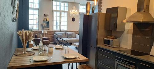 una cocina con una mesa con platos. en LA ROCHELAISE : Appartement calme & somptueux dans l'hyper centre. en La Rochelle