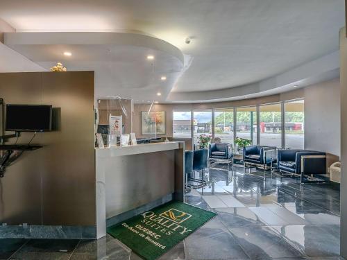 un vestíbulo con una sala de espera con sillas y un bar en Hotel Quality Suites, en Sainte-Anne-de-Beaupré