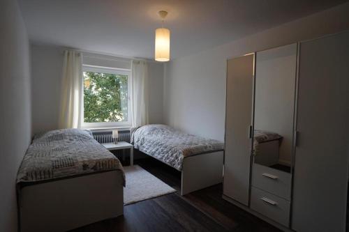 1 dormitorio con 2 camas y ventana en Gemütliche Unterkunft für bis zu 11 Personen. en Hannover