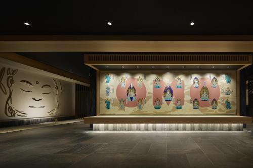 um quarto com uma parede com pinturas em OMO3 Kyoto Toji by Hoshino Resorts em Quioto