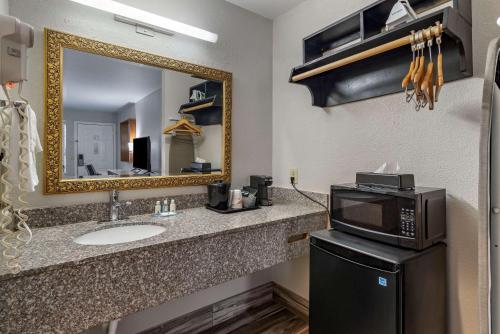 a bathroom with a sink and a microwave at Quality Inn Covington in Covington