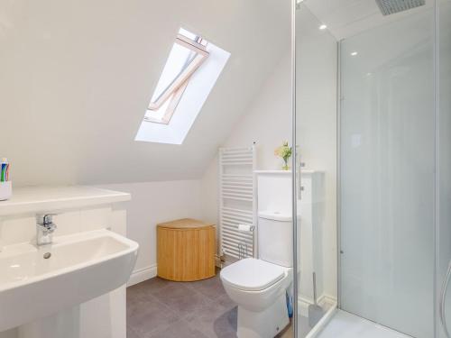 a bathroom with a sink toilet and a skylight at Honey Bee House in Woodhall Spa