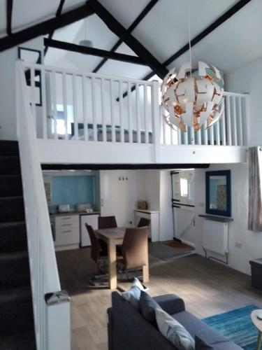 a living room with a table and a staircase at Pandy cymunod in Bryngwran