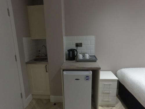 a small kitchen with a sink and a refrigerator at LBT Property LTD in London