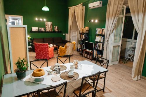 ein Wohnzimmer mit grünen Wänden sowie einem Tisch und Stühlen in der Unterkunft Green Chiaia in Neapel