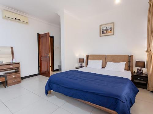 1 dormitorio con 1 cama, vestidor y TV en Unit 5, Capella Place en Accra