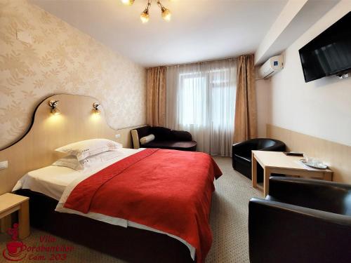 a hotel room with a bed and a chair at Vila Dorobantilor in Cluj-Napoca