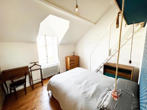 a bedroom with a bed and a desk and a window at Villa Sainte Claire in Saint Malo