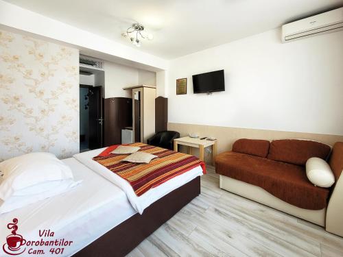 a hotel room with a bed and a couch at Vila Dorobantilor in Cluj-Napoca