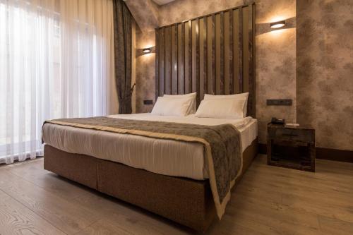 a bedroom with a large bed with a wooden headboard at Ankara Royal Hotel in Ankara