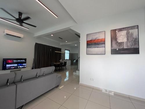 a living room with a couch and a dining room at Chen Villa Bukit Gambir 晨舍 in Bukit Gambir