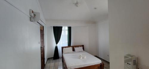 a small room with a bed and a window at Pride in Homestay 2 in Mombasa