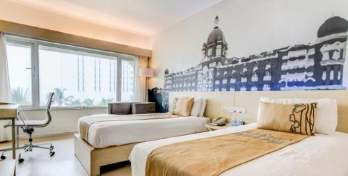 Cette chambre comprend 2 lits et une fenêtre. dans l'établissement The Gateway Hotel Beach Road Visakhapatnam, à Visakhapatnam