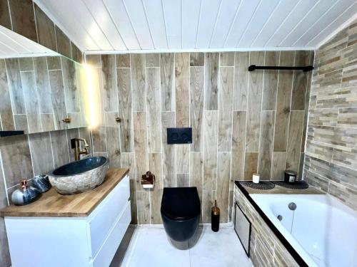 a bathroom with a tub and a sink and a toilet at The Cottage in Bocholt