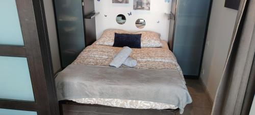 Cette petite chambre comprend un lit avec des draps bruns et des oreillers bleus. dans l'établissement Appartement cosy en bord de mer, à Six-Fours-les-Plages