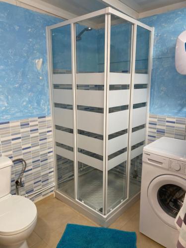 Un baño con inodoro y lavadora. en BLANCA FRENTE AL MAR, en Punta Mujeres