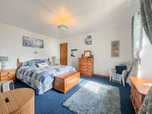 a bedroom with a bed and a table and a chair at Cuillin Cottage in Arnisdale