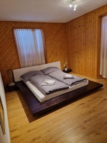 duże łóżko w pokoju z drewnianymi ścianami w obiekcie Haus Krone Whg 1 w mieście Gurtnellen