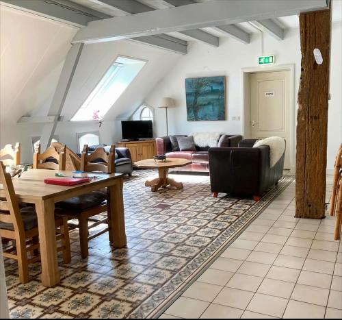 a living room with a couch and a table at Appartement met eigen sauna en sport-en spelruimte in Ee