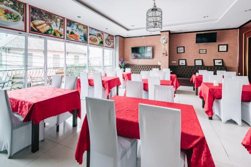 a restaurant with red and white tables and white chairs at View Hotel Vientiane in Vientiane