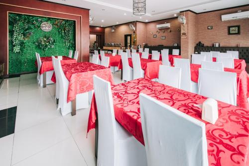 un comedor con mesas y sillas rojas y blancas en V Hotel Vientiane en Vientián